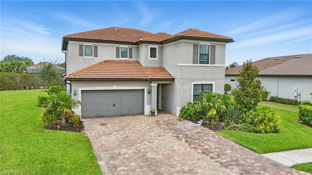 4934 Seton Way Ave Maria, FL 34142 - Photo 36 of 49 a front view of a house with a garden and garage