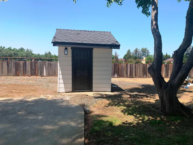 a view of a house with a backyard and a tree