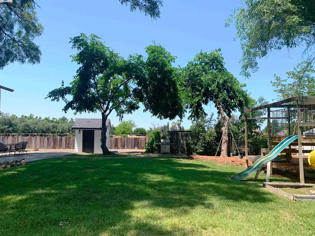 a backyard of a house with table and chairs