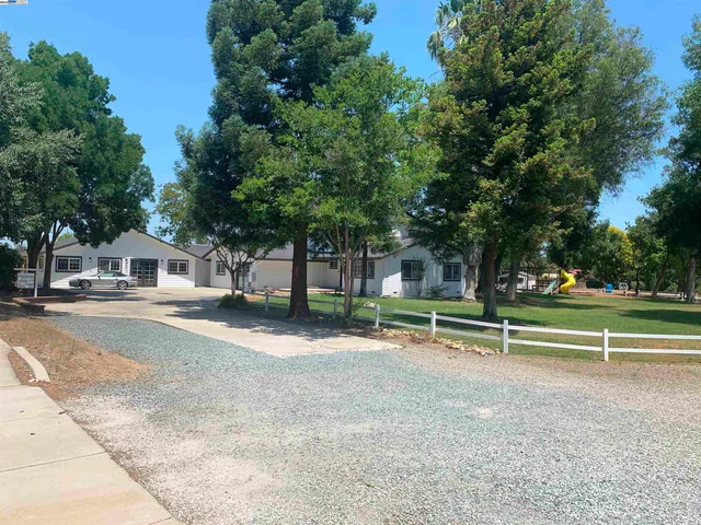 a view of a street with trees and bushes