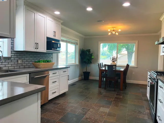 a kitchen with granite countertop white cabinets and stainless steel appliances