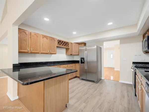a kitchen with stainless steel appliances granite countertop a refrigerator a sink and a stove