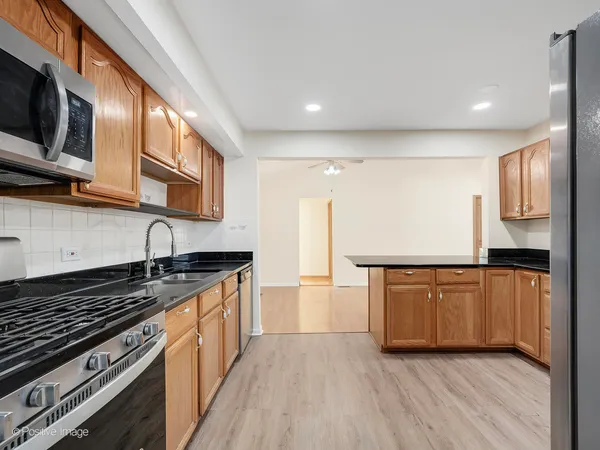 a kitchen with stainless steel appliances granite countertop a stove a sink and a microwave