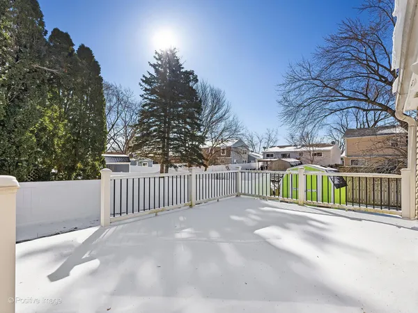 a view of a street with a fence and trees