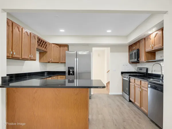 a kitchen with stainless steel appliances granite countertop a stove a sink and a refrigerator