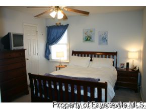 5018 Summer Ridge Road Fayetteville, NC 28303 - Photo 6 of 10 a bedroom with a bed and a flat tv screen on dresser