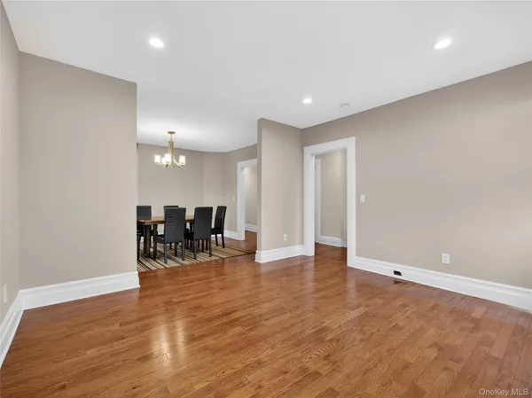 a view of an empty room and a kitchen