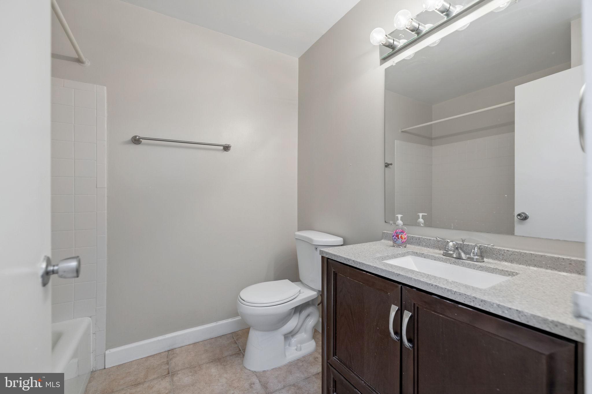 1443 Northgate Square, Unit 22B Reston, VA 20190 - Photo 13 of 42 a bathroom with a sink a toilet a mirror and vanity