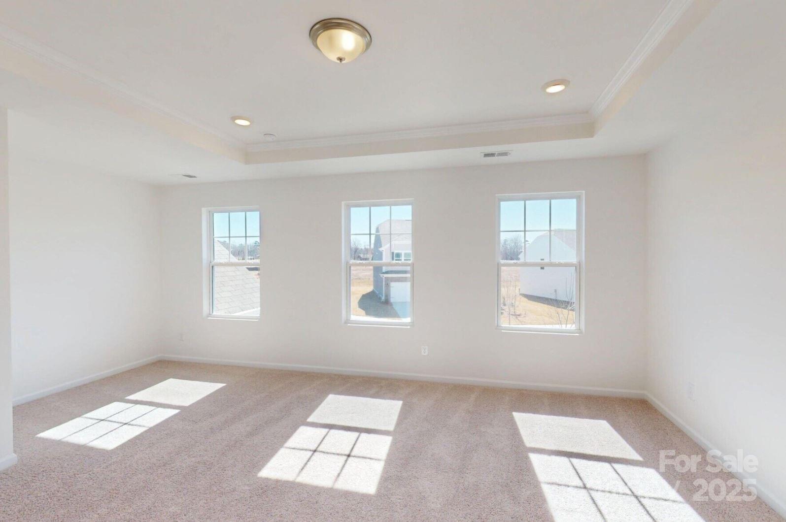 1829 Augustine Street Monroe, NC 28112 - Photo 18 of 21 an empty room with windows and chandelier fan