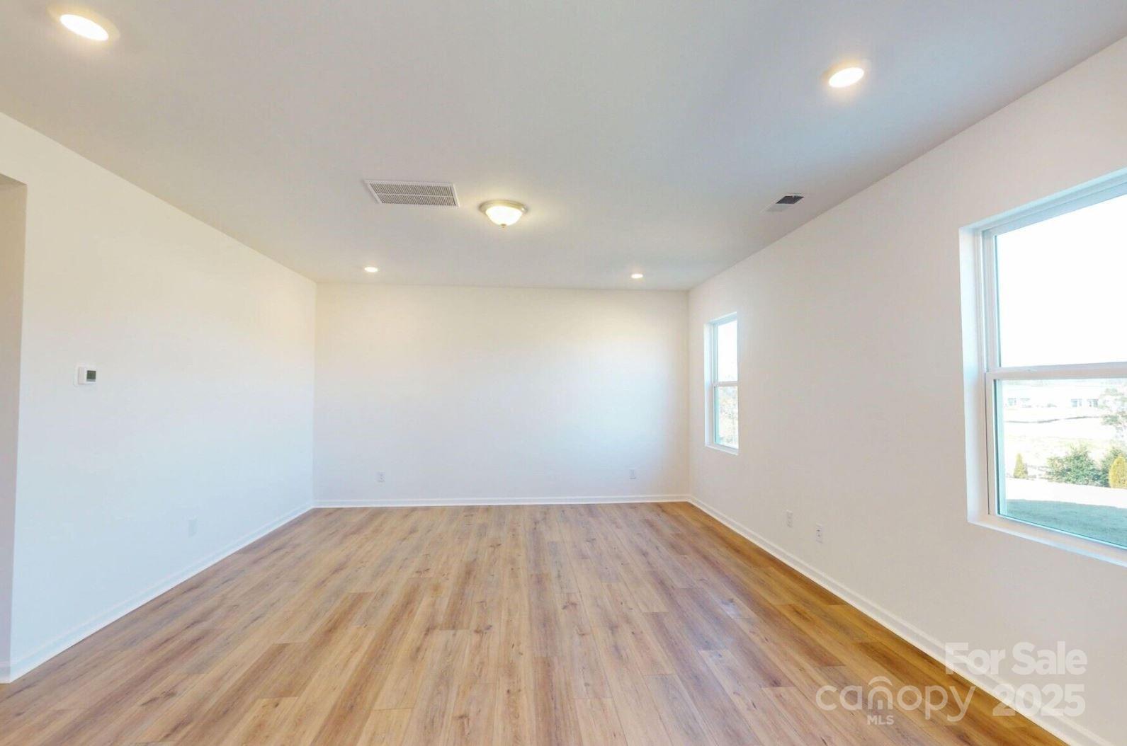 1829 Augustine Street Monroe, NC 28112 - Photo 6 of 21 an empty room with wooden floor and windows