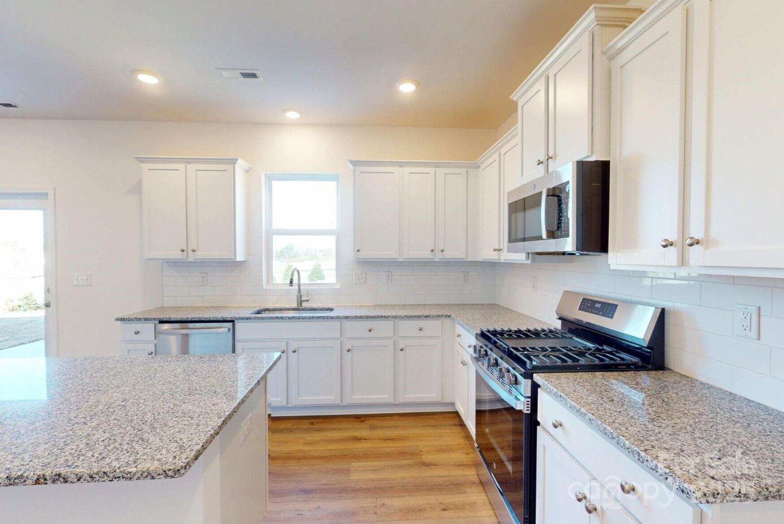 1829 Augustine Street Monroe, NC 28112 - Photo 9 of 21 a kitchen with stainless steel appliances granite countertop a sink stove and microwave