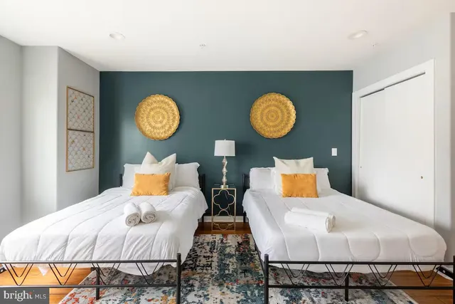 a bedroom with a bed and a lamp on dresser