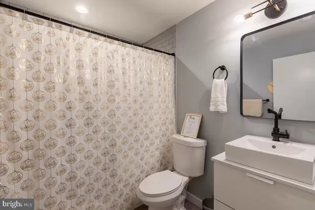 a bathroom with a toilet a sink and a mirror