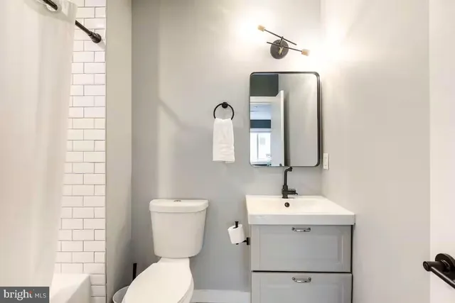 a bathroom with a toilet sink and mirror