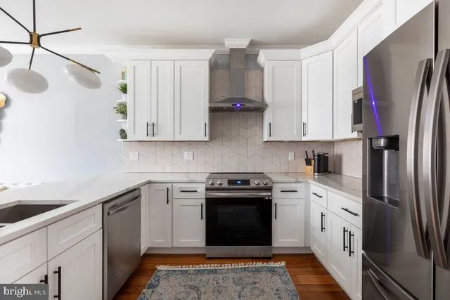 a kitchen with stainless steel appliances granite countertop a stove a sink and a refrigerator