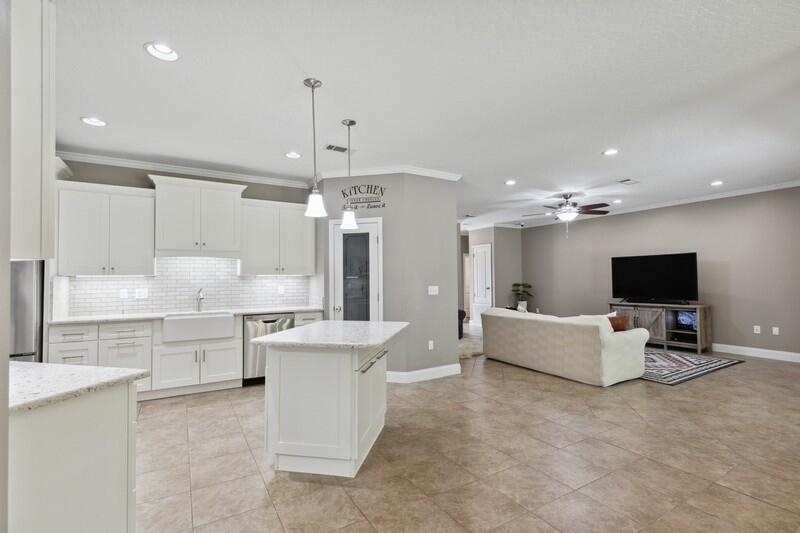 4542 Annabelle Lane Crestview, FL 32539 - Photo 11 of 36 a large living room with stainless steel appliances kitchen island granite countertop couches and a flat screen tv