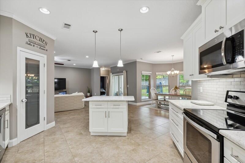 4542 Annabelle Lane Crestview, FL 32539 - Photo 14 of 36 a large kitchen with kitchen island a large counter top space appliances and cabinets