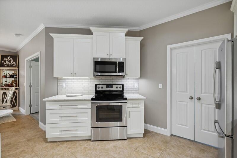 4542 Annabelle Lane Crestview, FL 32539 - Photo 15 of 36 a kitchen with white cabinets and stainless steel appliances