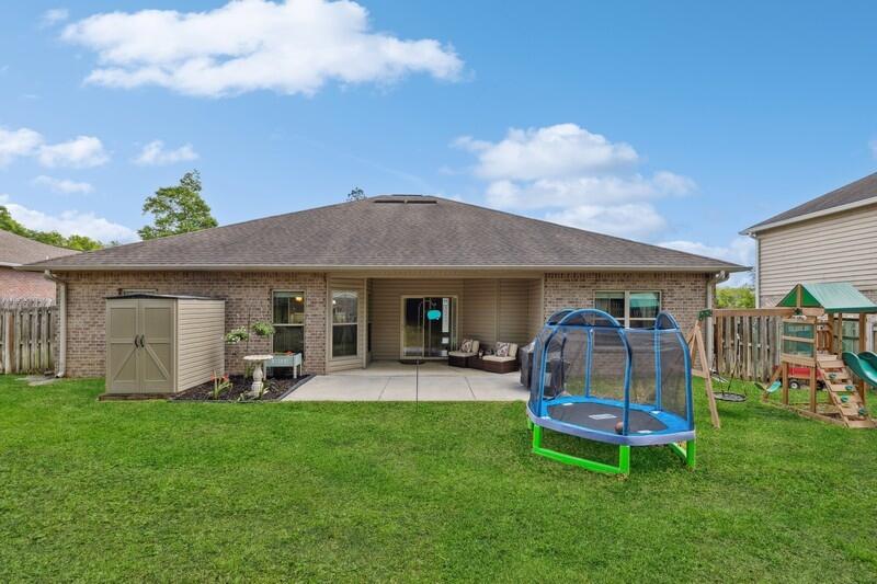 4542 Annabelle Lane Crestview, FL 32539 - Photo 34 of 36 a view of a backyard with table and chairs and a barn with wooden fence