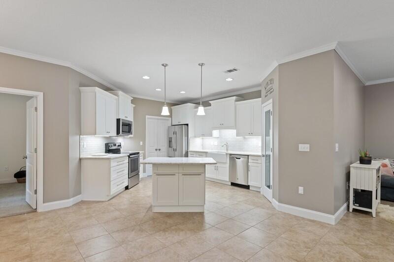 4542 Annabelle Lane Crestview, FL 32539 - Photo 9 of 36 a large white kitchen with a refrigerator a stove a sink and a cabinets