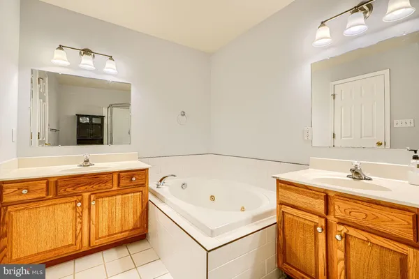 a bathroom with a tub sink and mirror