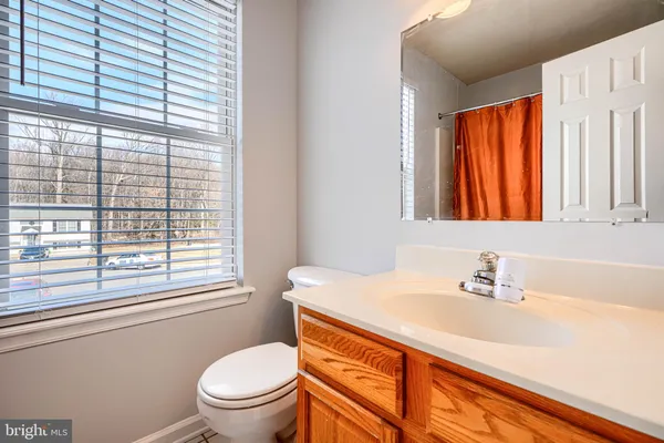 a bathroom with a sink a toilet and a window