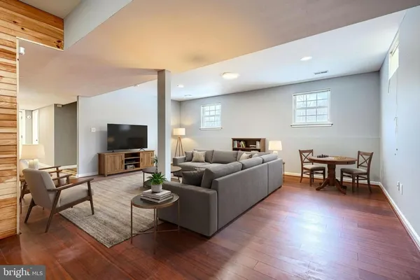 a living room with furniture a flat screen tv and a large window