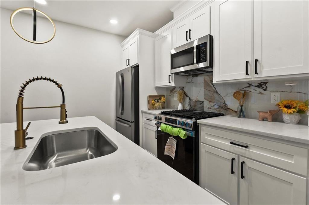 5580 Burrus Road Austell, GA 30106 - Photo 21 of 53 a kitchen with stainless steel appliances a sink a stove and cabinets