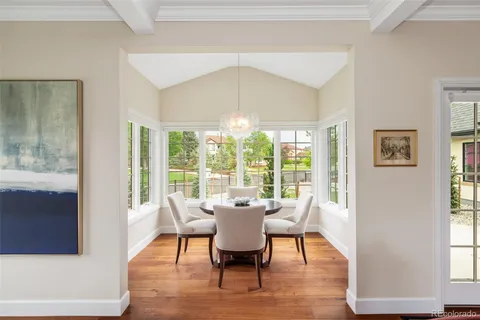 a dining room with furniture a chandelier and wooden floor