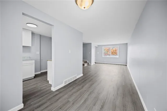 a view of a room with wooden floor and a window