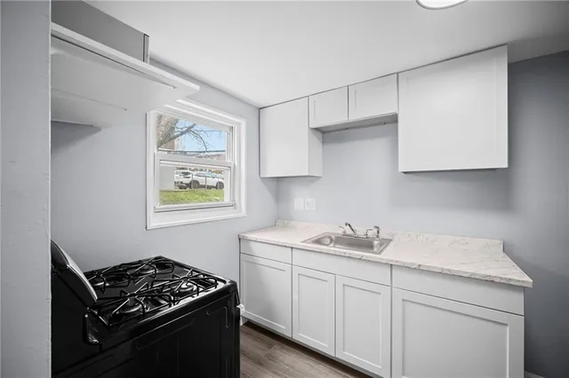 a kitchen with stainless steel appliances white cabinets and a stove top oven