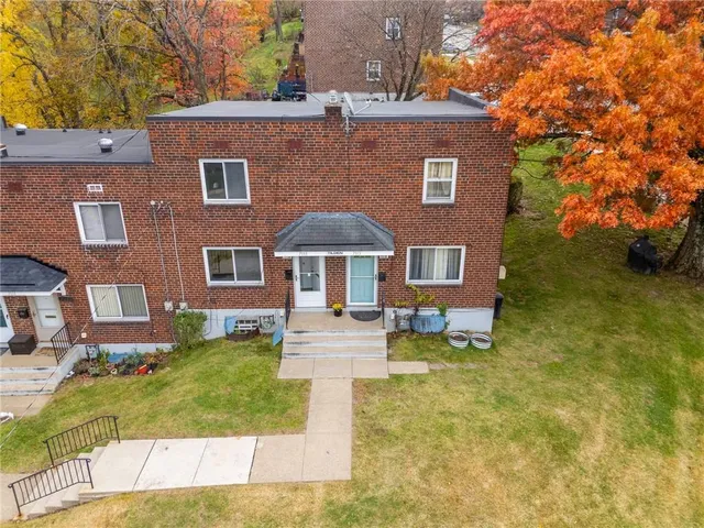 a front view of a house with yard and trees