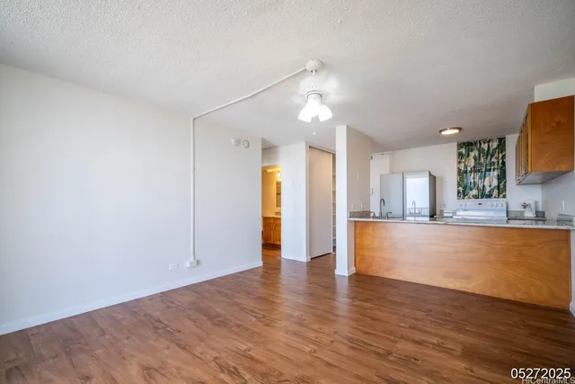 a view of kitchen and hall with wooden floor