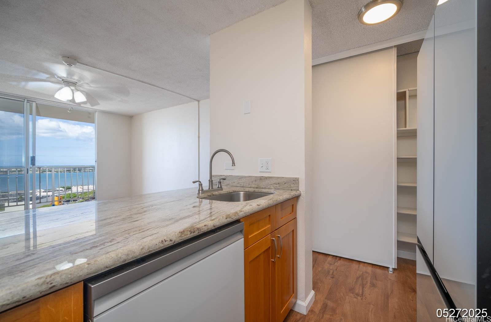 98-99 Uao Place, Unit 1705 Aiea, HI 96701 - Photo 17 of 25 a kitchen with a sink and a refrigerator