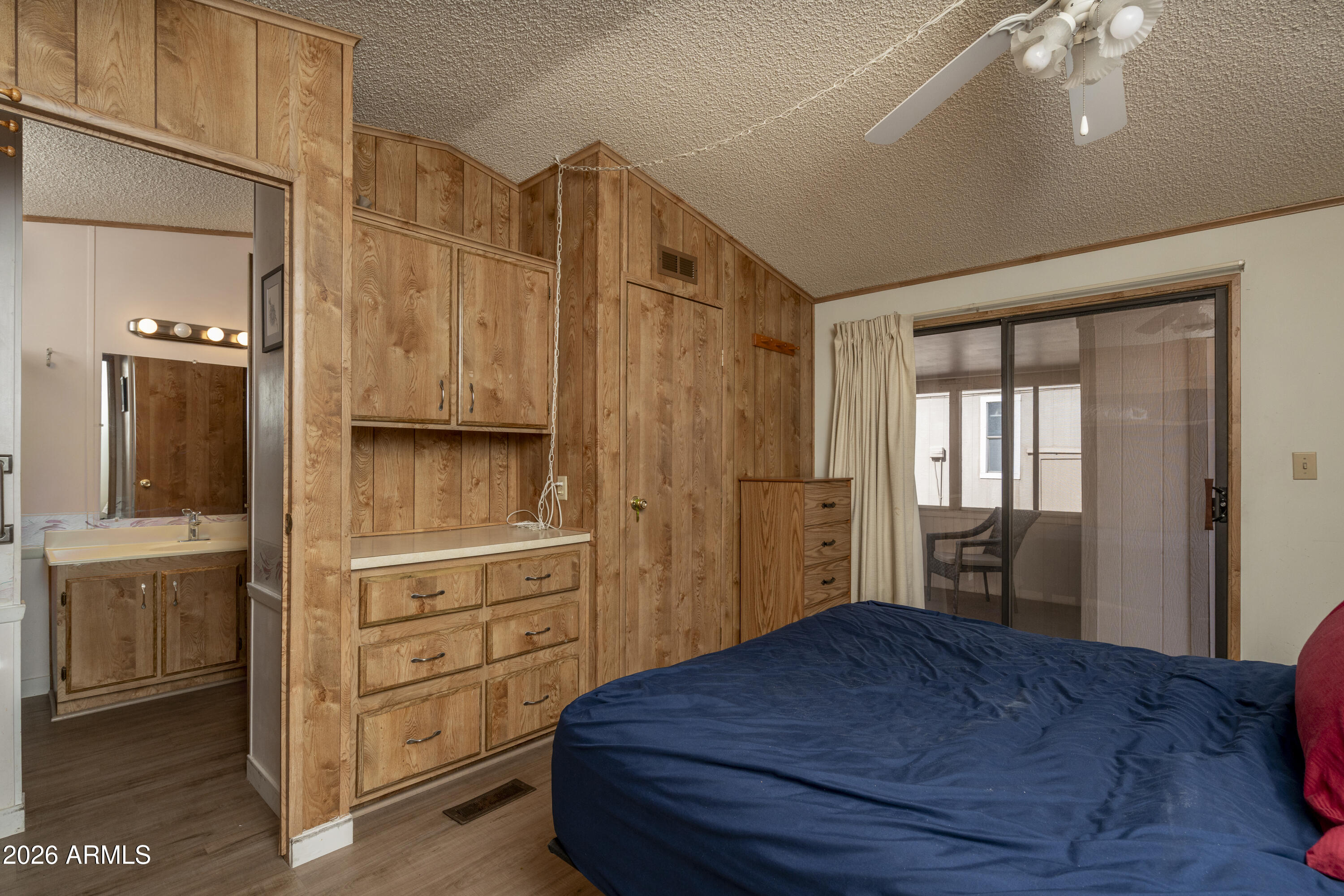 5735 East McDowell Road, Unit 466 Mesa, AZ 85215 - Photo 10 of 19 a bedroom with a bed and wooden floor