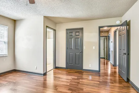 a view of a livingroom with wooden floor and a bathroom