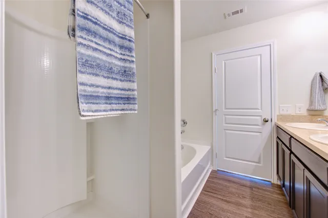 a bathroom with a granite countertop sink and a bathtub