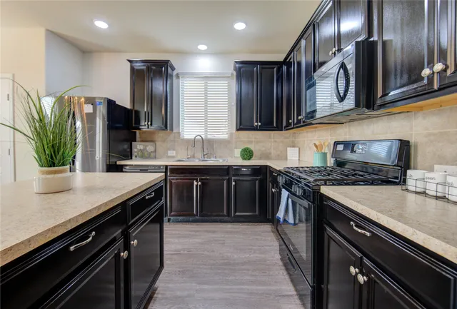 a kitchen with stainless steel appliances granite countertop a sink stove and cabinets