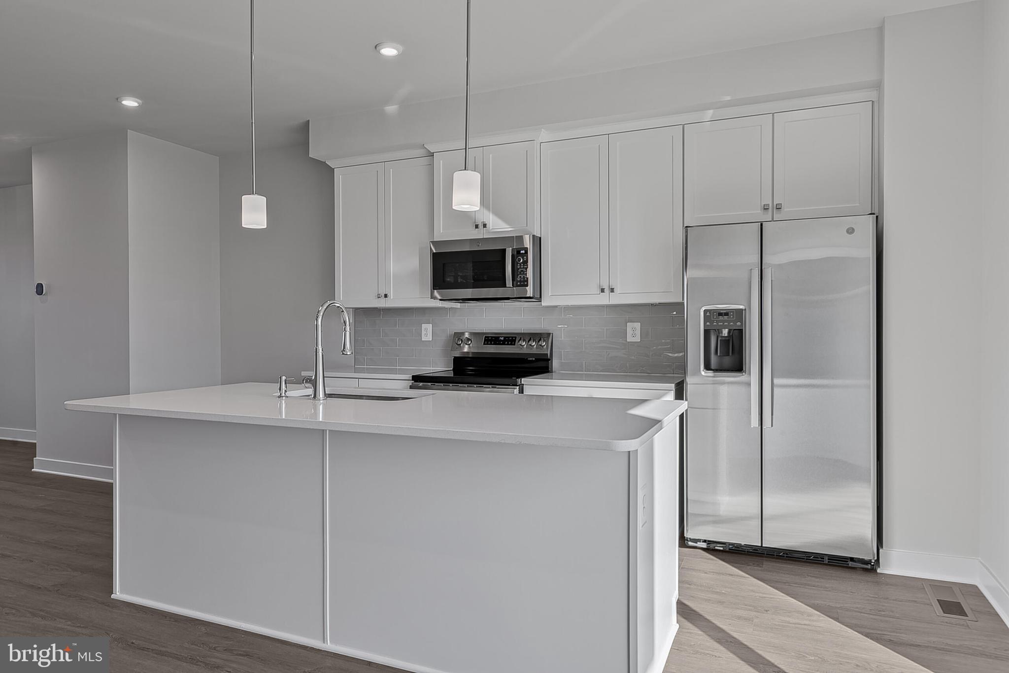 70 C Oasis Avenue Ranson, WV 25438 - Photo 12 of 41 a kitchen with stainless steel appliances a refrigerator a sink a stove a microwave and island