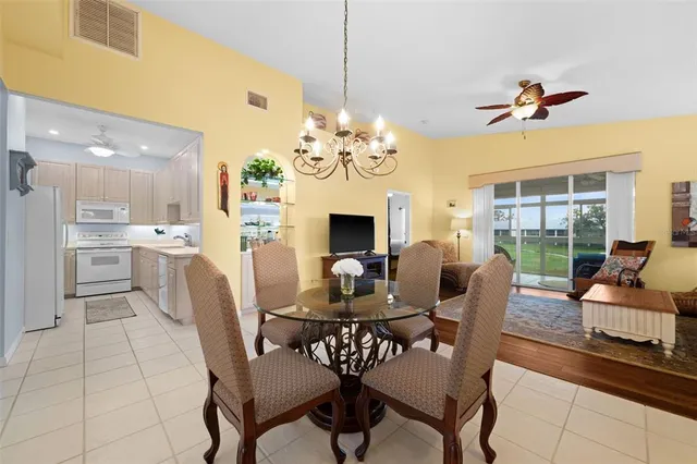 a view of a dining room with furniture a chandelier and wooden floor