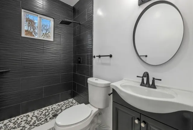 a bathroom with a sink a toilet and a mirror