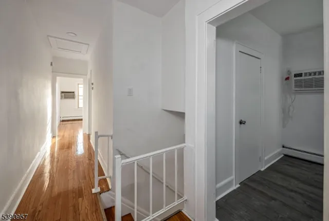 a view of a hallway with wooden floor and entryway