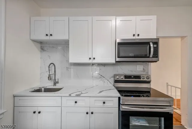a kitchen with cabinets stainless steel appliances and a sink