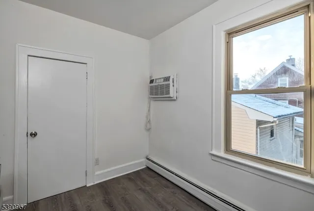 a view of a small space with wooden floor and a window