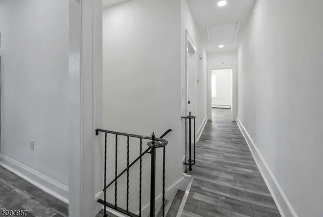 a view of a hallway with wooden floor and staircase