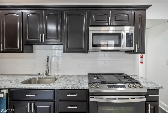 a kitchen with granite countertop stainless steel appliances and cabinets