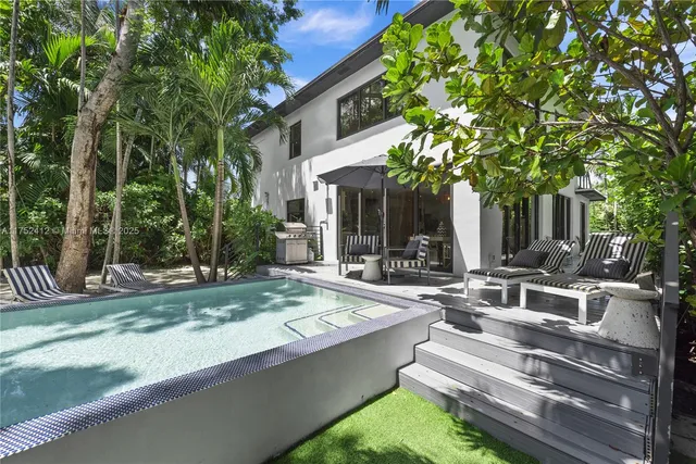 a view of house with yard outdoor seating and tree in beside