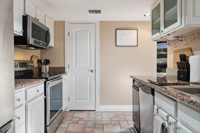 a kitchen with stainless steel appliances granite countertop a refrigerator and a stove top oven