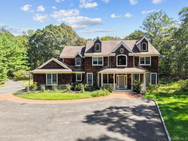 a front view of a house with a yard and potted plants
