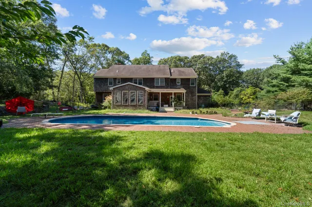 a house view with swimming pool and garden space